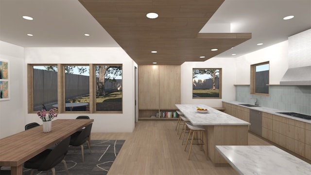 kitchen featuring stainless steel dishwasher, wood-type flooring, decorative backsplash, sink, and a kitchen island