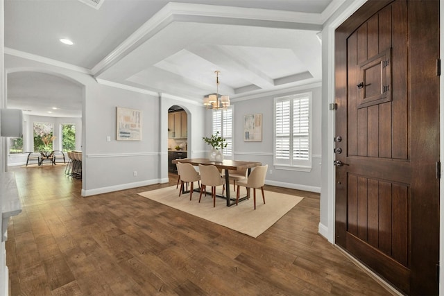 dining room with wood-type flooring, coffered ceiling, crown molding, and an inviting chandelier