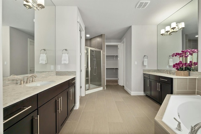 bathroom with separate shower and tub, tile patterned floors, vanity, and a notable chandelier