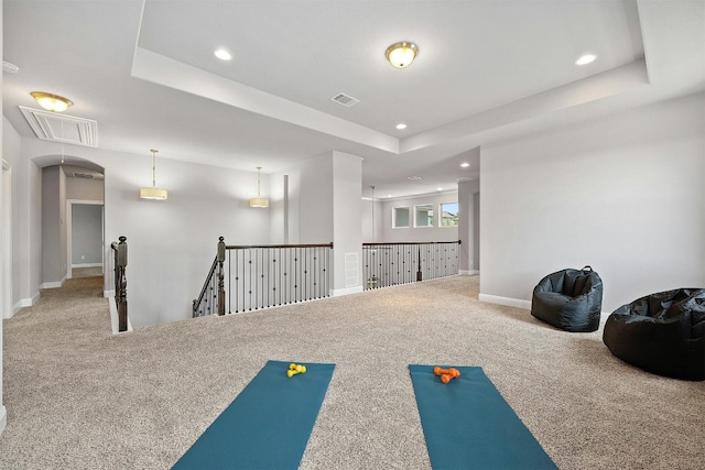 workout room with carpet floors and a tray ceiling