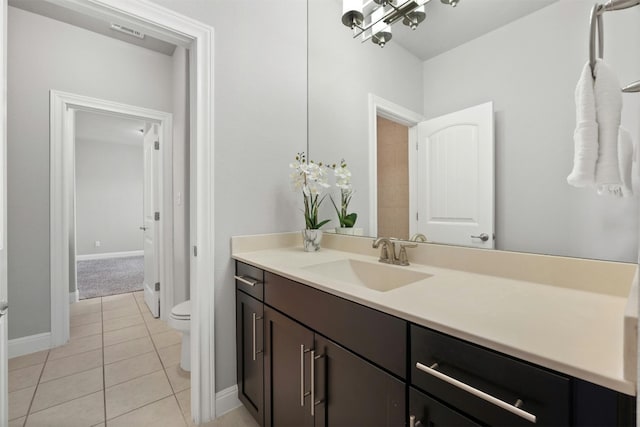 bathroom with tile patterned flooring, vanity, and toilet