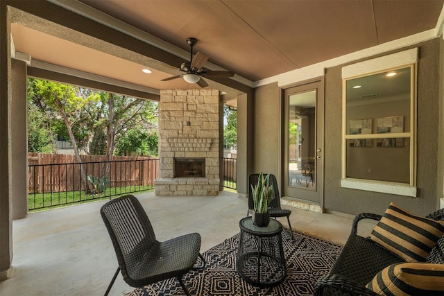 view of patio with ceiling fan and an outdoor stone fireplace