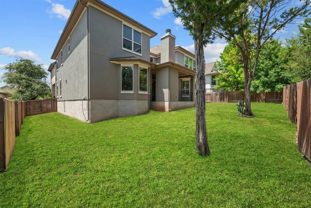 rear view of property with a lawn