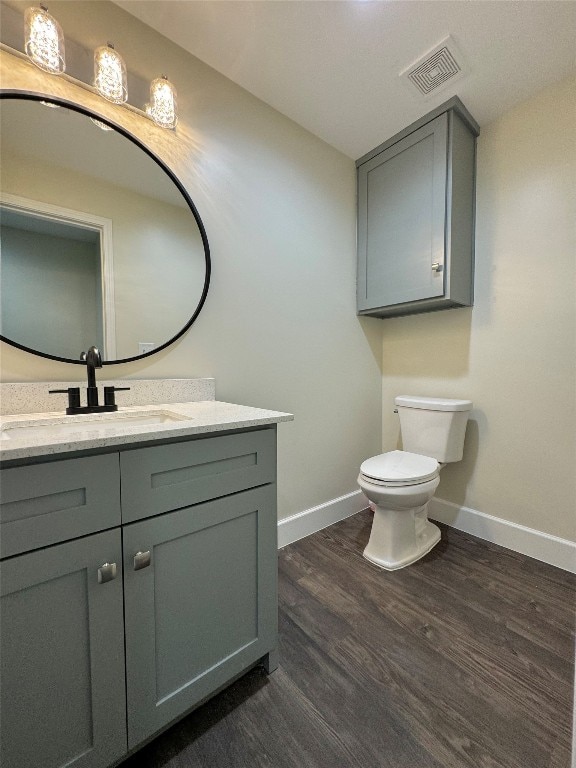 bathroom with vanity, toilet, and hardwood / wood-style flooring