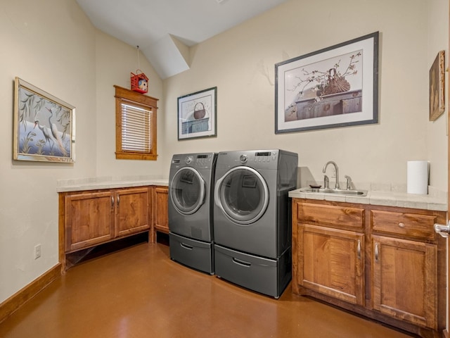 laundry room with cabinet space, baseboards, separate washer and dryer, and a sink