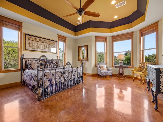 bedroom featuring baseboards, multiple windows, visible vents, and a tray ceiling