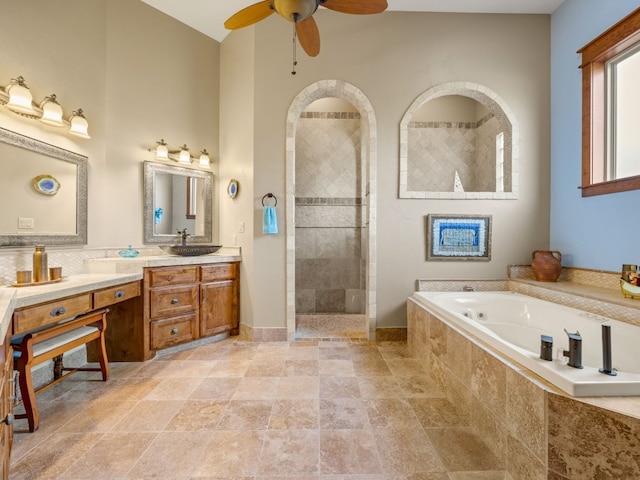 full bath with baseboards, ceiling fan, a garden tub, vanity, and a walk in shower