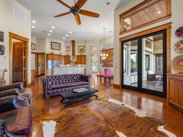 living area with recessed lighting, finished concrete floors, visible vents, and ceiling fan with notable chandelier