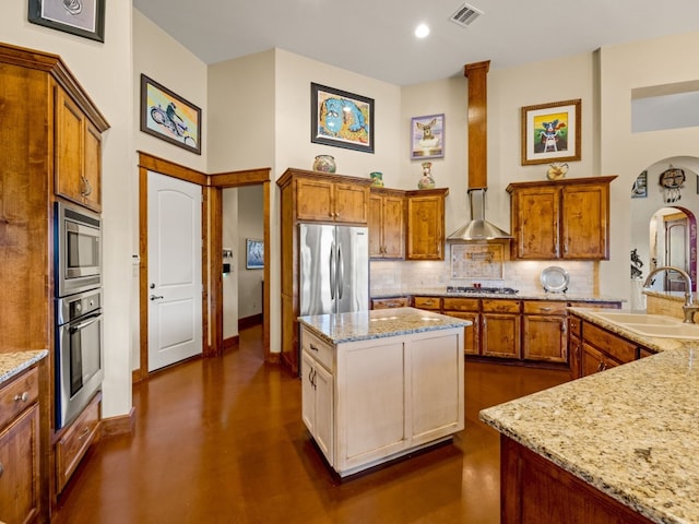 kitchen with arched walkways, decorative backsplash, visible vents, stainless steel appliances, and a sink