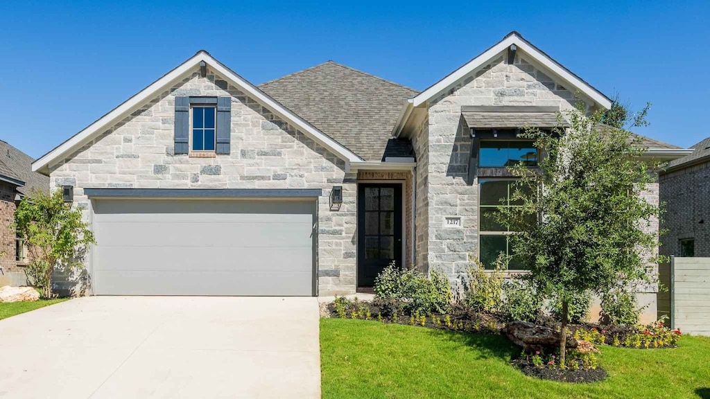 view of front of property featuring a garage and a front lawn