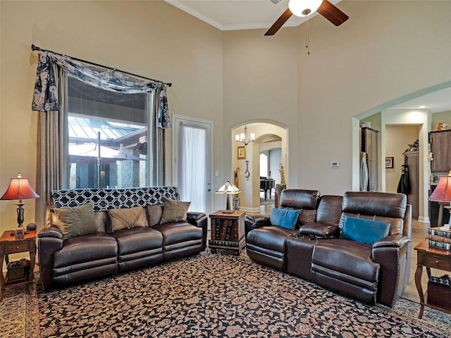 living room with ceiling fan, carpet, and a high ceiling