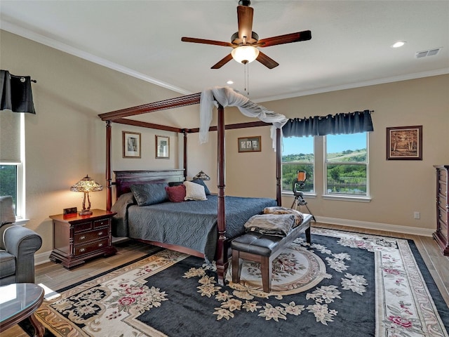 bedroom featuring ceiling fan, crown molding, and hardwood / wood-style flooring