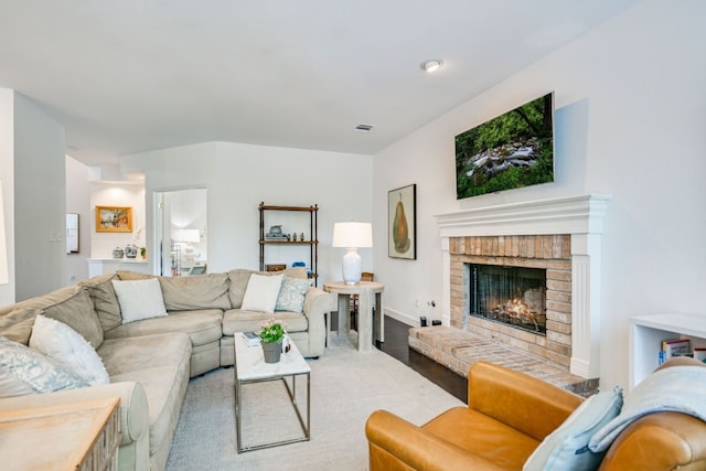 living room featuring a brick fireplace and hardwood / wood-style floors