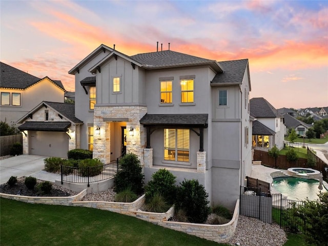 view of front of property featuring a garage, an in ground hot tub, and a yard