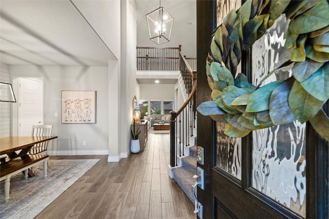 foyer entrance featuring wood-type flooring and a chandelier