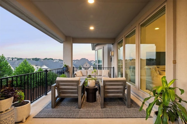 balcony at dusk featuring an outdoor living space