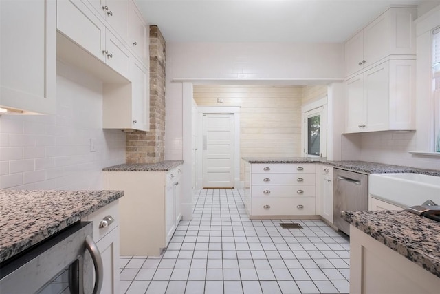 kitchen with wine cooler, light stone countertops, white cabinetry, stainless steel dishwasher, and decorative backsplash