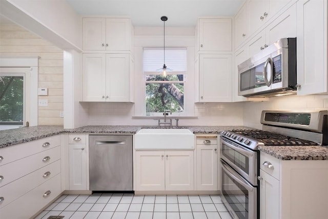 kitchen with white cabinets, decorative backsplash, stainless steel appliances, and a sink