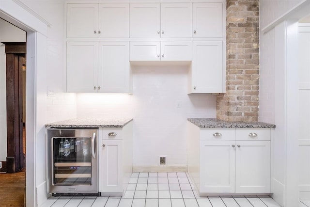 kitchen featuring light stone counters, beverage cooler, and backsplash