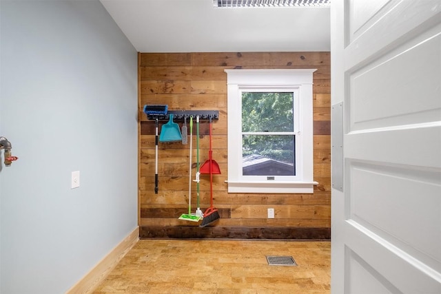 mudroom with wood walls, baseboards, and visible vents