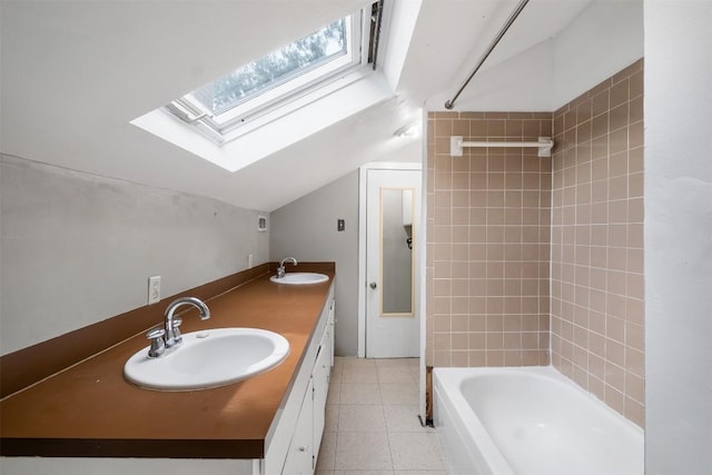 bathroom featuring tile patterned flooring, vaulted ceiling with skylight, shower / tub combination, and a sink