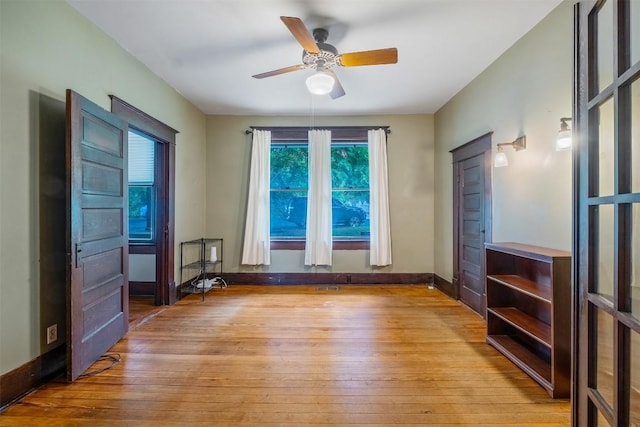 interior space featuring baseboards, ceiling fan, and hardwood / wood-style floors