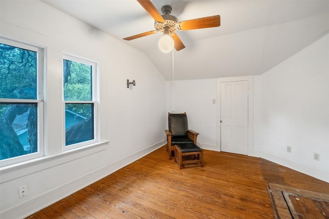 unfurnished room featuring vaulted ceiling, wood-type flooring, a ceiling fan, and baseboards