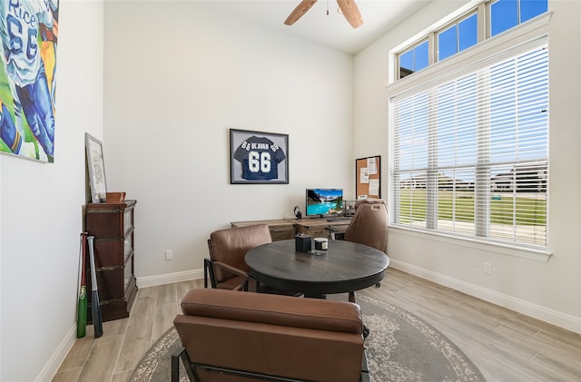 living area featuring ceiling fan, a wealth of natural light, and light wood-type flooring