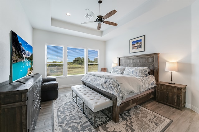 bedroom featuring ceiling fan and a raised ceiling