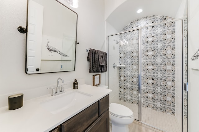 bathroom with a shower with door, toilet, vanity, and vaulted ceiling