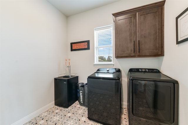 laundry area with light tile patterned floors, independent washer and dryer, and cabinets