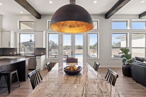 dining room featuring beam ceiling and light wood-type flooring