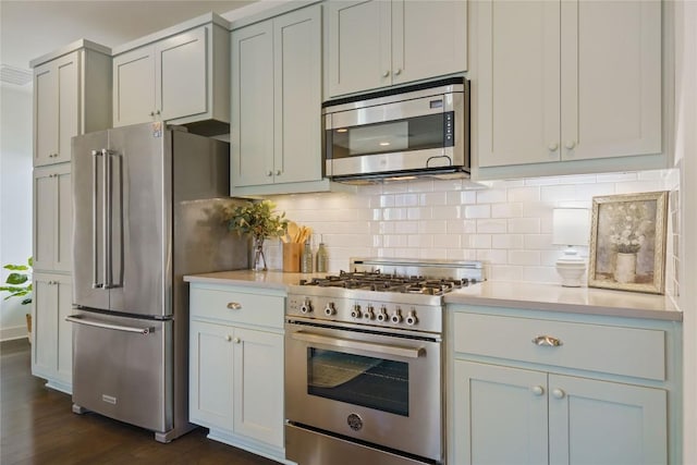 kitchen featuring backsplash, high quality appliances, and dark wood-type flooring