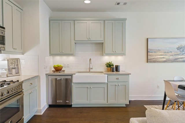 kitchen with decorative backsplash, sink, dark wood-type flooring, and appliances with stainless steel finishes