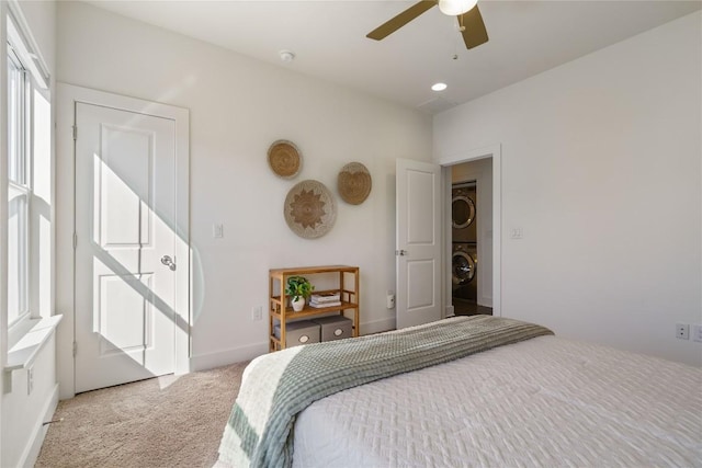 carpeted bedroom with stacked washing maching and dryer and ceiling fan