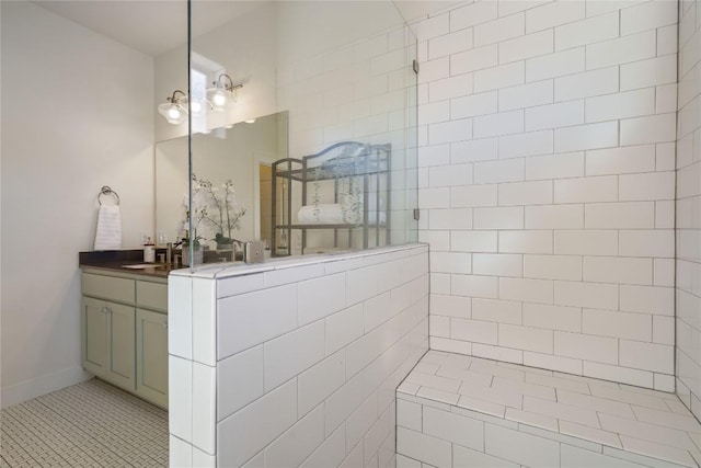 bathroom with tile patterned flooring, vanity, and tiled shower