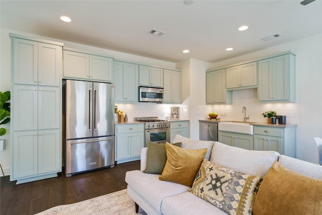 kitchen with backsplash, dark hardwood / wood-style floors, high end appliances, and sink