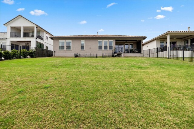 back of property with a balcony and a lawn