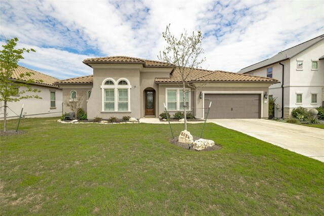 mediterranean / spanish home with a garage and a front yard