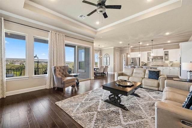 living room featuring wood-type flooring, a raised ceiling, crown molding, and ceiling fan