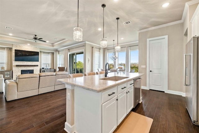 kitchen with high end white fridge, dark hardwood / wood-style flooring, a kitchen island with sink, and white cabinetry