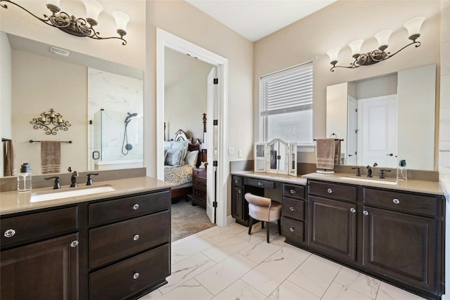 bathroom featuring marble finish floor, a stall shower, two vanities, and a sink