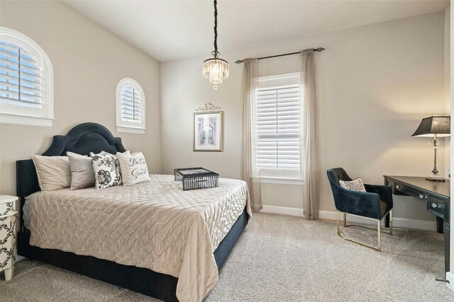 carpeted bedroom featuring multiple windows and a chandelier