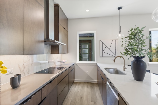 kitchen featuring black electric stovetop, dishwasher, wall chimney range hood, pendant lighting, and sink