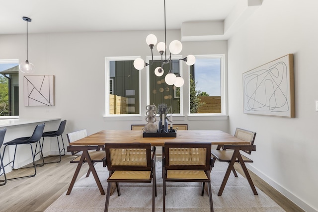 dining room with wood-type flooring and a notable chandelier