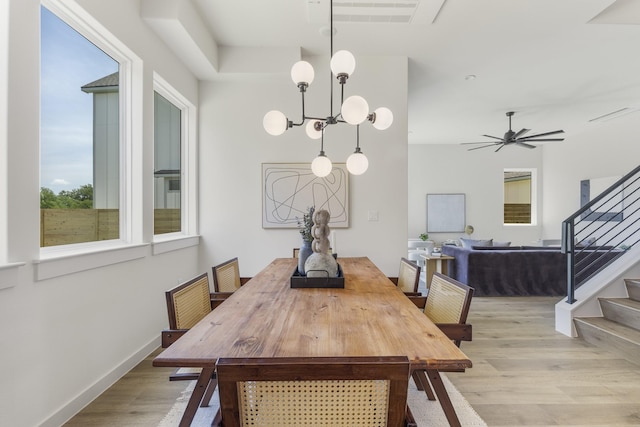 dining area featuring ceiling fan with notable chandelier and light hardwood / wood-style floors