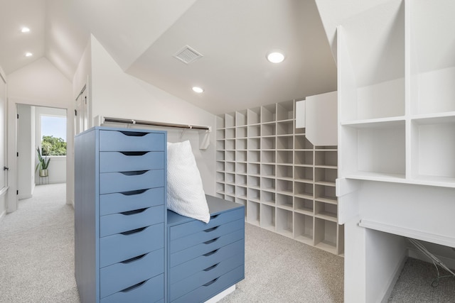 spacious closet with vaulted ceiling and light colored carpet