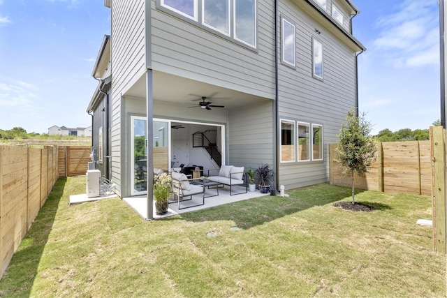 rear view of house with ceiling fan, a yard, an outdoor living space, and a patio