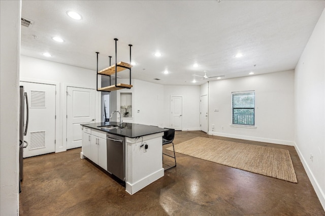 kitchen with a kitchen island with sink, a kitchen breakfast bar, sink, stainless steel dishwasher, and white cabinets