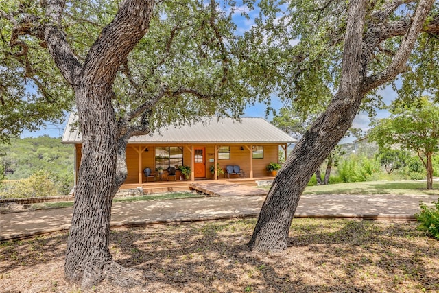 rear view of property with metal roof and a porch